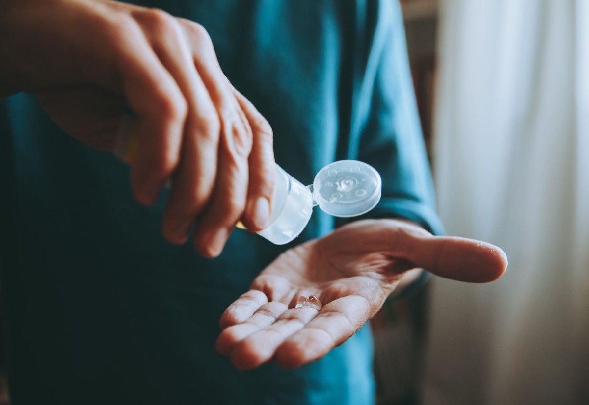 一名男子用酒精消毒剂洗手以防病毒。