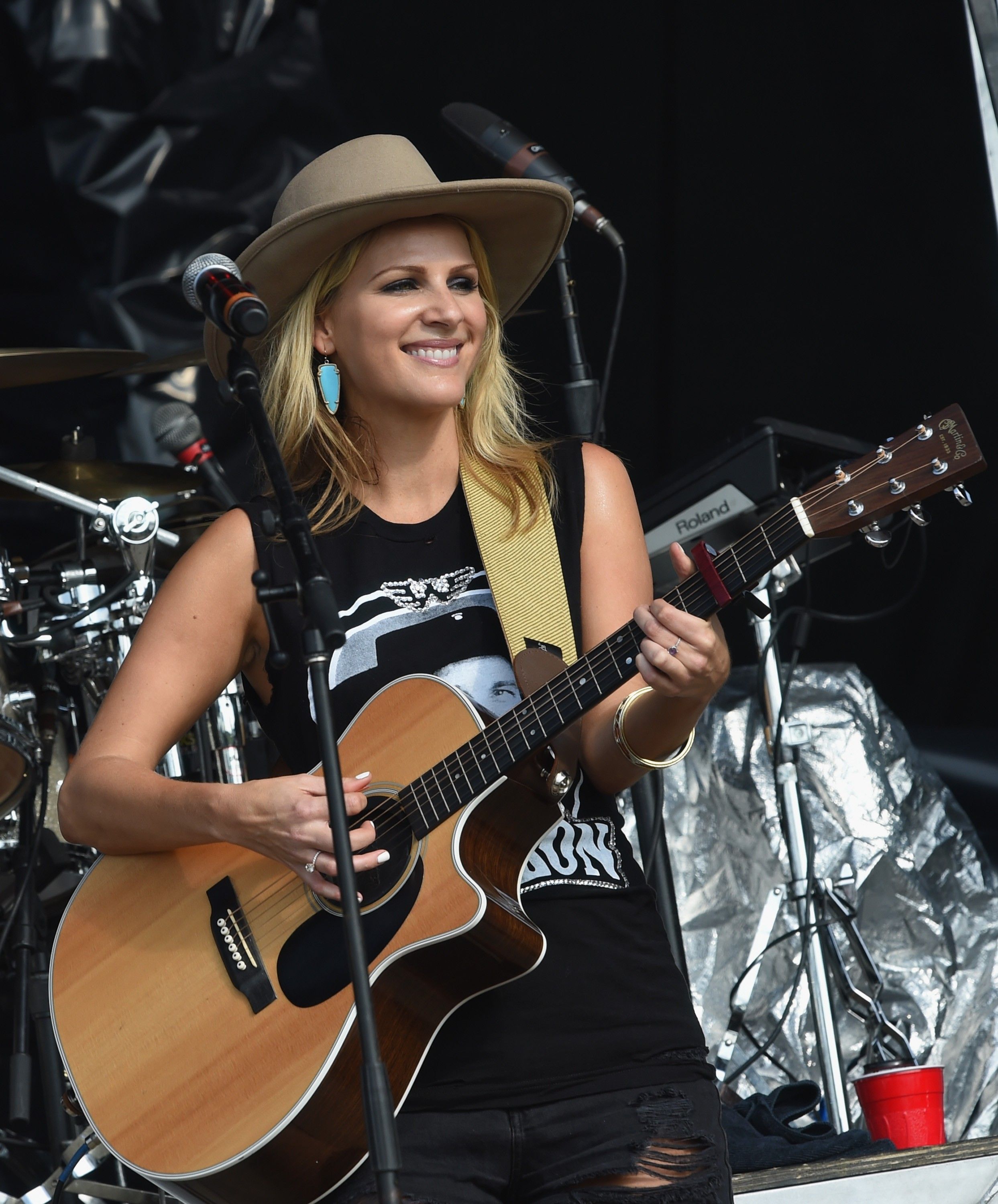 Jennifer Wayne in cowboy hat with guitar